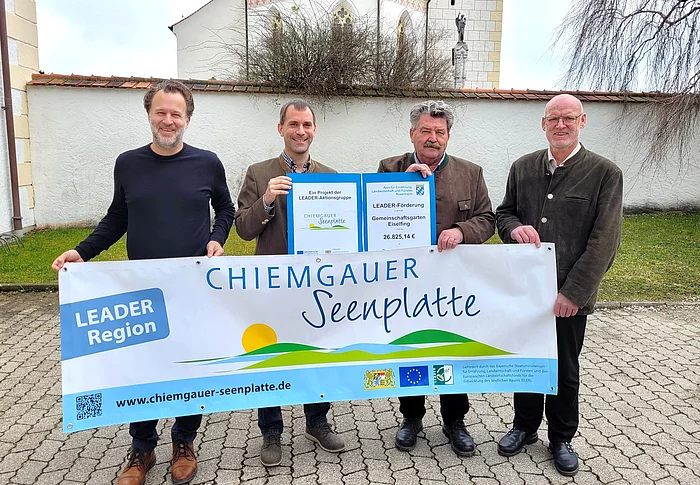 Das Foto zeigt die Übergabe eines Förderbescheids vor dem Rathaus in Eiselfing.
